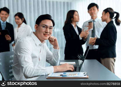 Portrait of focus young successful confident male manager, executive wearing business wear in harmony office arm crossed with blurred meeting background of colleagues, office worker.. Portrait of focus successful confident male manager in harmony office.