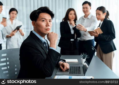 Portrait of focus young successful confident male manager, executive wearing business wear in harmony office arm crossed with blurred meeting background of colleagues, office worker.. Portrait of focus successful confident male manager in harmony office.