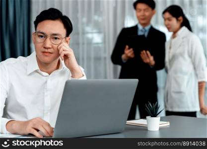 Portrait of focus young successful confident male manager, executive wearing business wear in harmony office arm crossed with blurred meeting background of colleagues, office worker.. Portrait of focus successful confident male manager in harmony office.