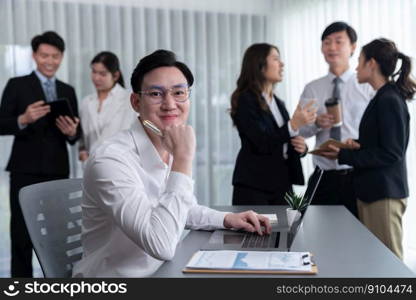 Portrait of focus young successful confident male manager, executive wearing business wear in harmony office arm crossed with blurred meeting background of colleagues, office worker.. Portrait of focus successful confident male manager in harmony office.