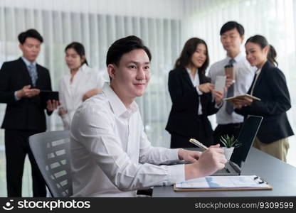 Portrait of focus young successful confident male manager, executive wearing business wear in harmony office arm crossed with blurred meeting background of colleagues, office worker.. Portrait of focus successful confident male manager in harmony office.