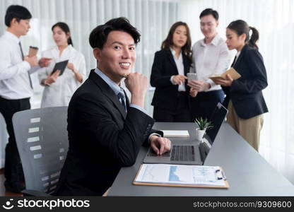 Portrait of focus young successful confident male manager, executive wearing business wear in harmony office arm crossed with blurred meeting background of colleagues, office worker.. Portrait of focus successful confident male manager in harmony office.