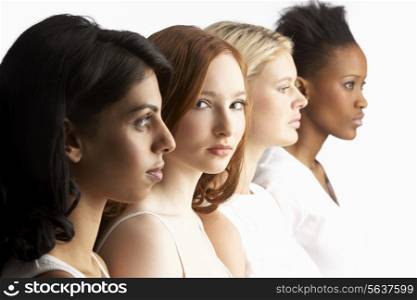 Portrait Of Four Attractive Young Women In Studio Standing In Line