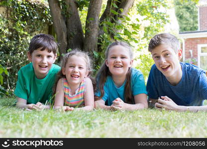 Portrait Of Four Brothers And Sisters Lying In Garden At Home