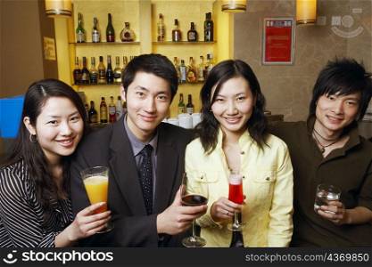 Portrait of four friends holding drinks