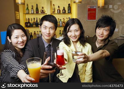 Portrait of four friends holding drinks