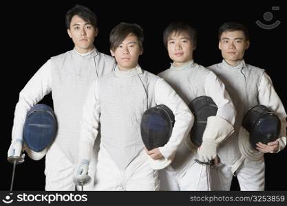 Portrait of four male fencers holding fencing foils and fencing masks