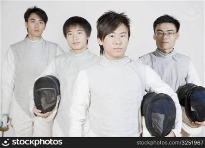 Portrait of four male fencers standing