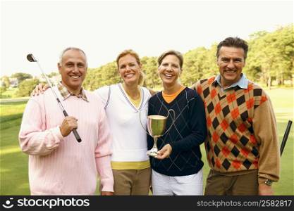 Portrait of four people holding a trophy