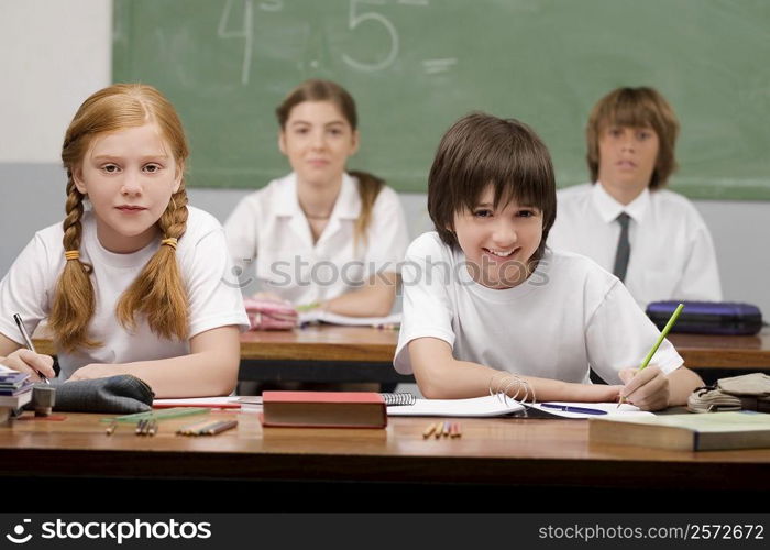 Portrait of four school students sitting in a classroom
