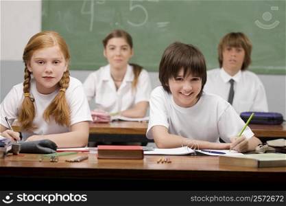 Portrait of four school students sitting in a classroom