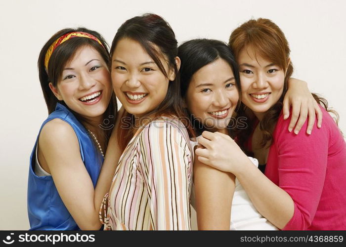 Portrait of four young women hugging each other and posing