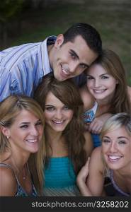 Portrait of four young women smiling with a young man