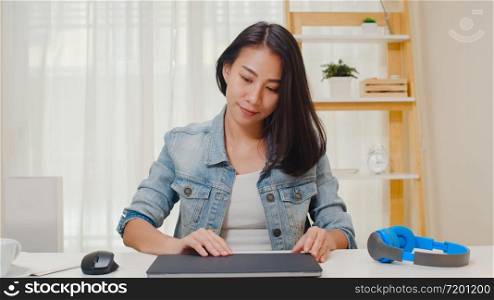 Portrait of freelance smart business women casual wear using laptop working in workplace in living room at home. Happy young Asian girl relax sitting on desk search and do job in internet.