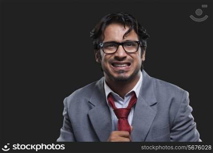 Portrait of frustrated businessman against black background