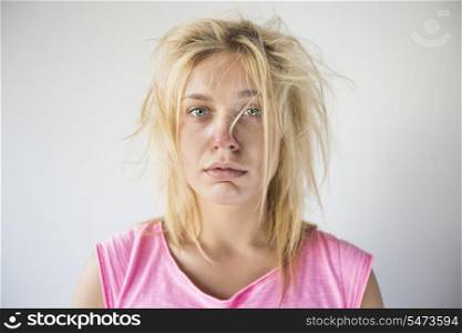 Portrait of frustrated woman suffering from cold against gray background