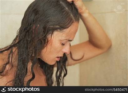 Portrait of frustrated young woman in shower