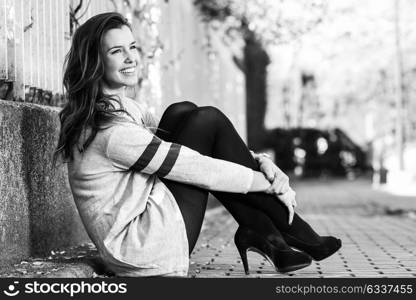 Portrait of funny female model of fashion with high heels sitting on the floor