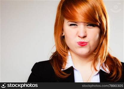 Portrait of funny redhair business woman or student girl making silly face. Studio shot on gray background