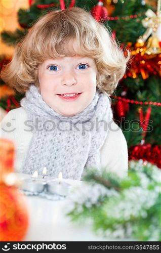 Portrait of funny smiling child against decorated Christmas background