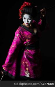 Portrait of geisha dancing with sword isolated on black