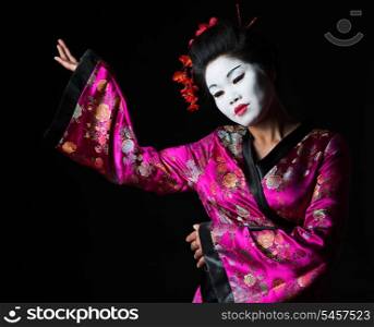Portrait of geisha showing on something isolated on black