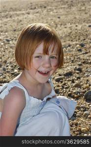 Portrait of girl (5-6) on beach laughing