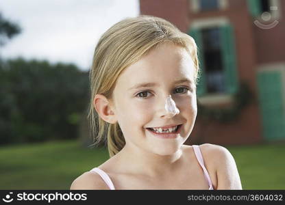 Portrait of girl (5-6) with sunscreen on nose