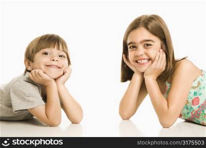 Portrait of girl and boy smiling against white background.