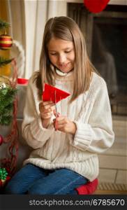 Portrait of girl cutting paper snowflakes for decorations on Christmas