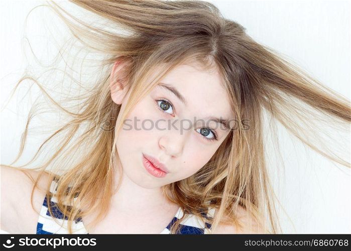 Portrait of girl eleven years old with big eyes playing with long hair
