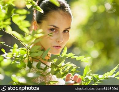 Portrait of girl hiding in foliage