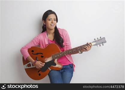 Portrait of girl playing on guitar
