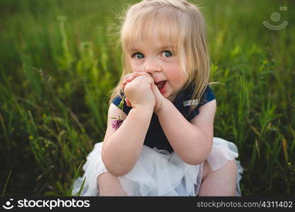 Portrait of girl sitting on grass looking at camera