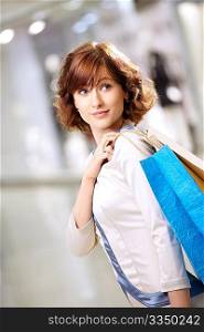 Portrait of girl standing in a half-turn with packages in shop