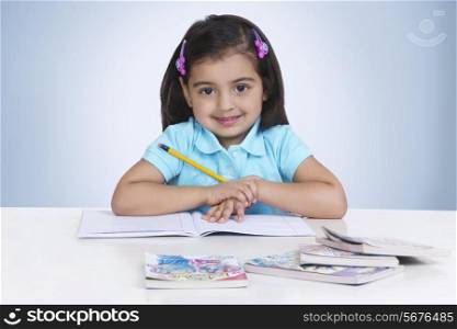 Portrait of girl studying against blue background