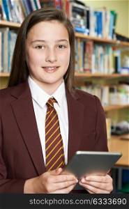 Portrait Of Girl Wearing School Uniform Using Digital Tablet In Library