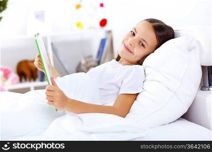 Portrait of girl with a book in bed at home