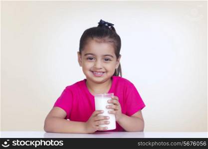 Portrait of girl with glass of milk against colored background