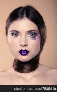 Portrait of girl young woman with long straight hair and creative makeup on brown. Studio shot.