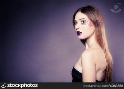 Portrait of girl young woman with long straight hair and creative makeup on violet. Blank copy space. Studio shot.