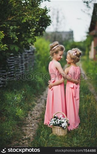 Portrait of girls on a country path.. Childrens portrait girlfriends in a pink dress in the garden 6617.