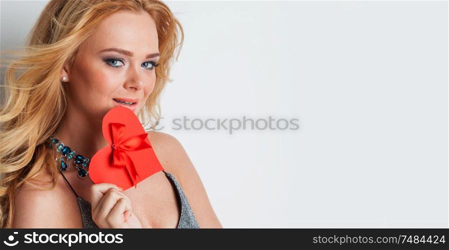 Portrait of glamorous woman holding red paper heart, valentine day concept. Woman holding red paper heart