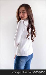 Portrait of good-looking beautiful young asian adult girl wearing white sweater for winter pointing to blank copy space on white background
