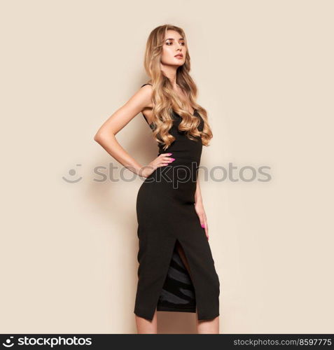 Portrait of gorgeous elegant sensual blonde woman wearing fashion black dress isolated on white background. Model woman with long curly hairstyle. Care and beauty hair product