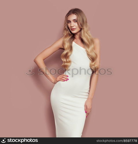 Portrait of gorgeous elegant sensual blonde woman wearing fashion white dress isolated on beige background. Model woman with long curly hairstyle. Care and beauty hair product