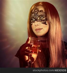 Portrait of gorgeous woman wearing mask on carnival, holding in hand glass with champagne, having fun on luxury Christmas party