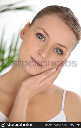 portrait of graceful blonde stroking her face