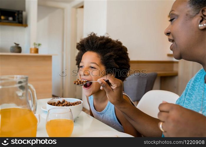 Portrait of grandmother and grandchild having breakfast together at home. Family and lifestyle concept.