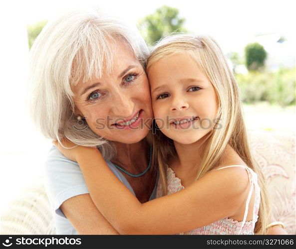 Portrait Of Grandmother With Granddaughter Relaxing Together On Sofa